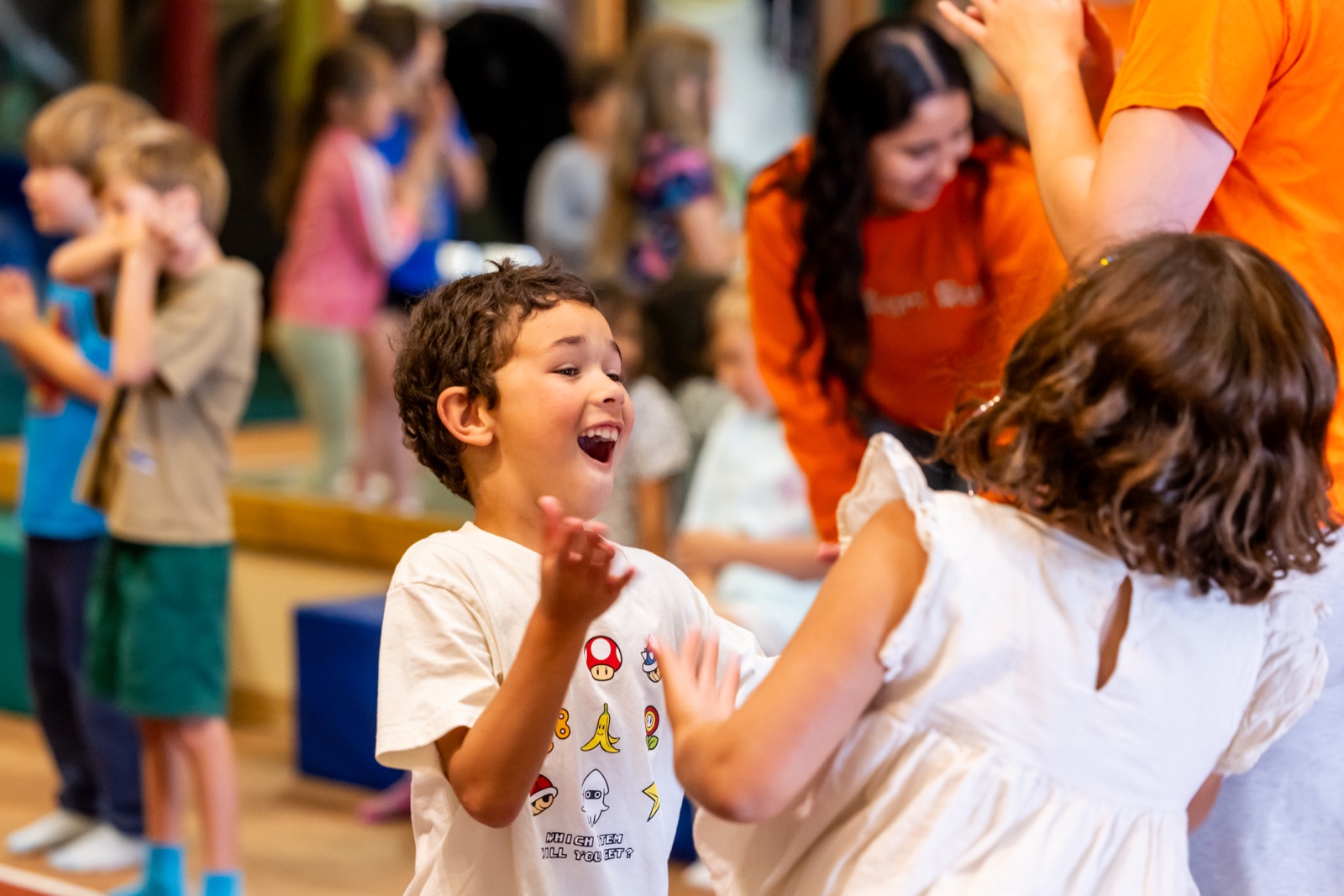 A Safari Run staffer and a smiling kid inside the play structure at Kids' Night Out