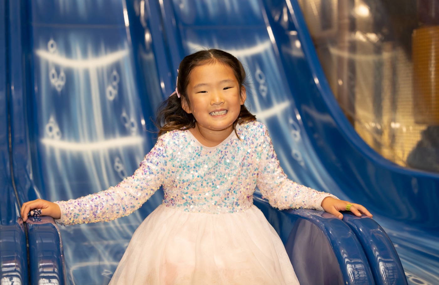 A smiling girl on the blue slide at Safari Run Sunnyvale